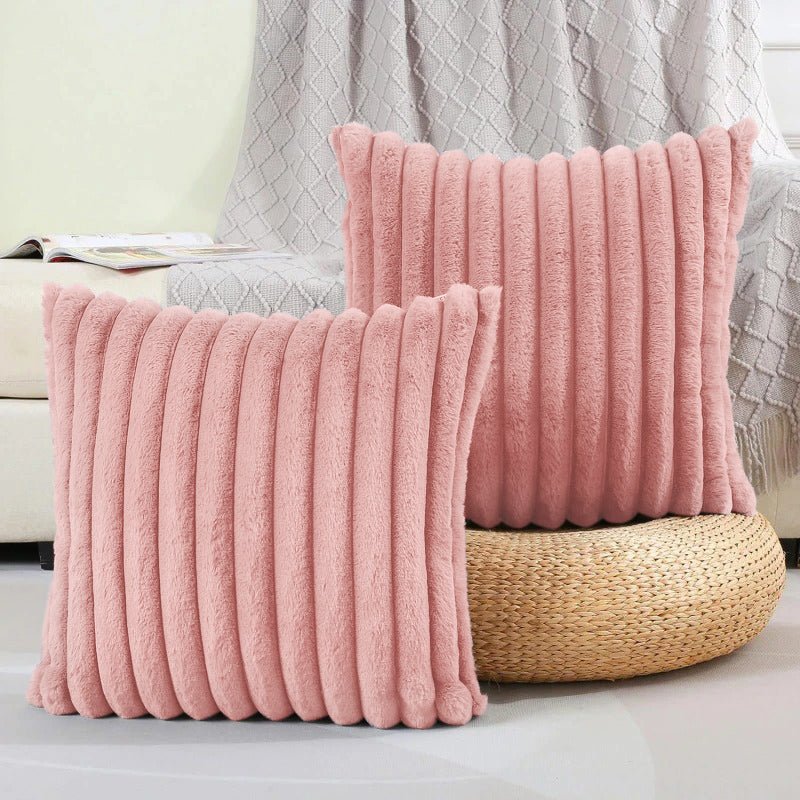 Two pink textured pillows on a couch with a neutral background