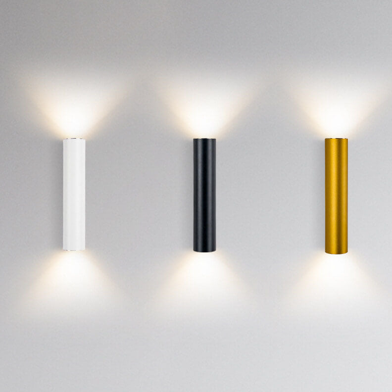 Three cylindrical wall lights in white, black, and gold on a gray background