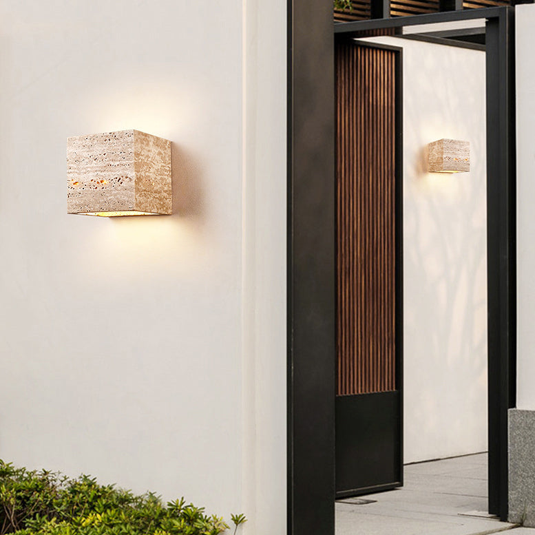 Modern outdoor wall lights on a building exterior with a door in the background.