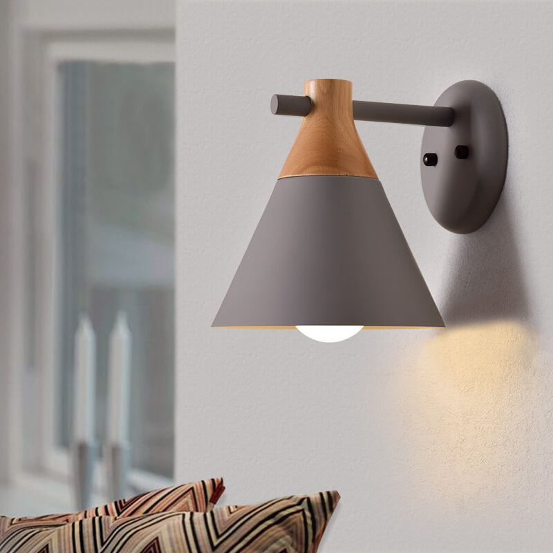 Wall-mounted lamp with wooden top and gray shade on a white wall.