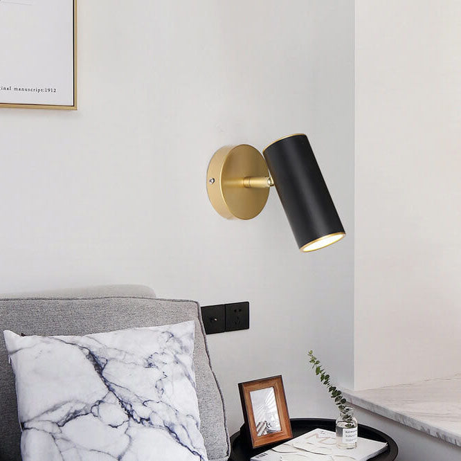 Modern wall sconce with gold and black finish in a living room setting.