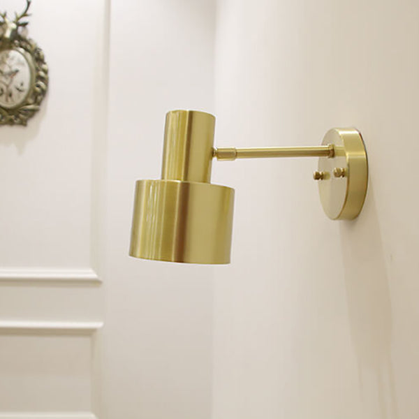 Gold wall-mounted lamp on a white wall