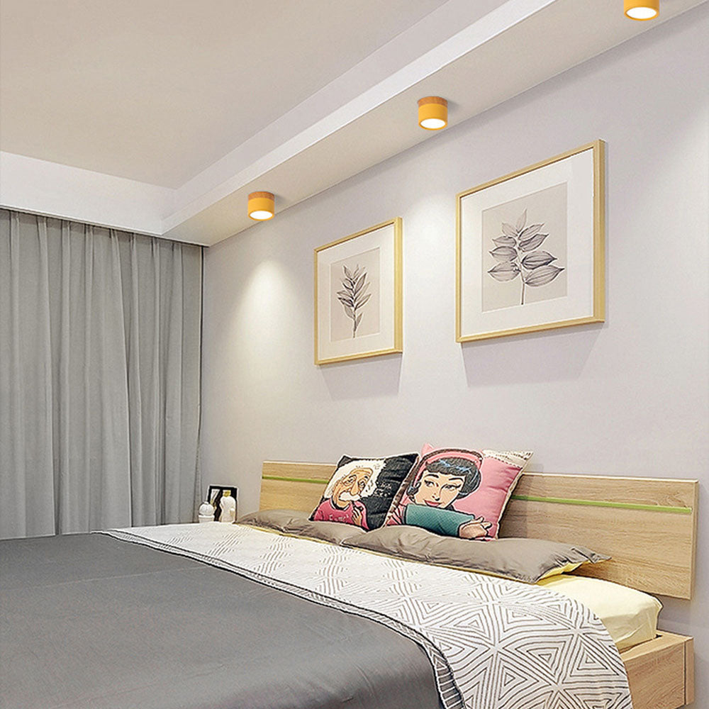 Modern bedroom with a bed, decorative pillows, and framed artwork on the wall.