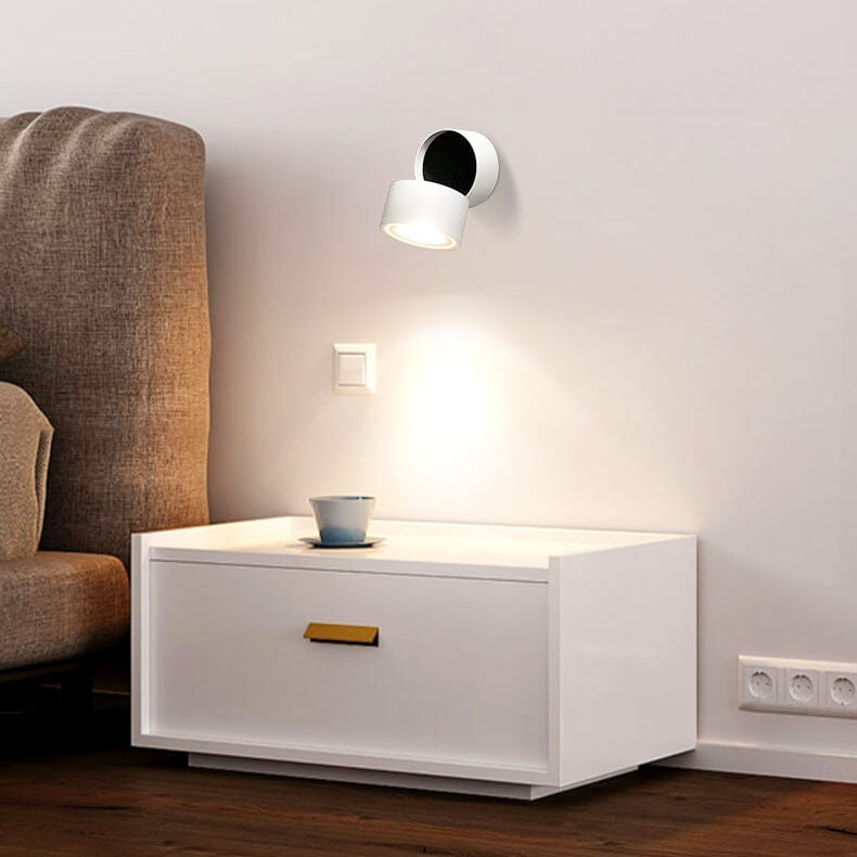 Modern interior with a white side table, armchair, and wall-mounted light fixture.