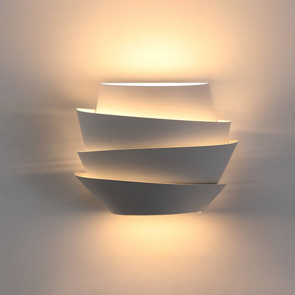 Modern wall-mounted light fixture with three tiered design on a neutral background