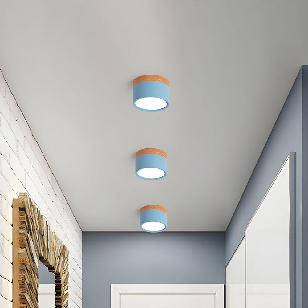 Three blue ceiling lights with orange accents on a white ceiling.