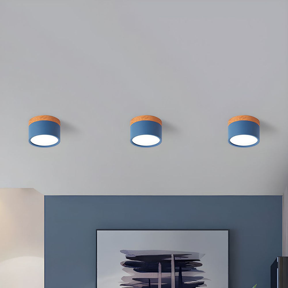 Three cylindrical ceiling lights with blue shades and orange accents on a gray ceiling.