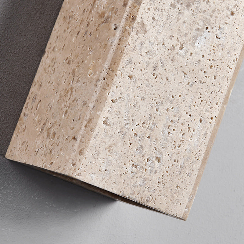 Close-up of a beige stone tile with a textured surface on a gray background