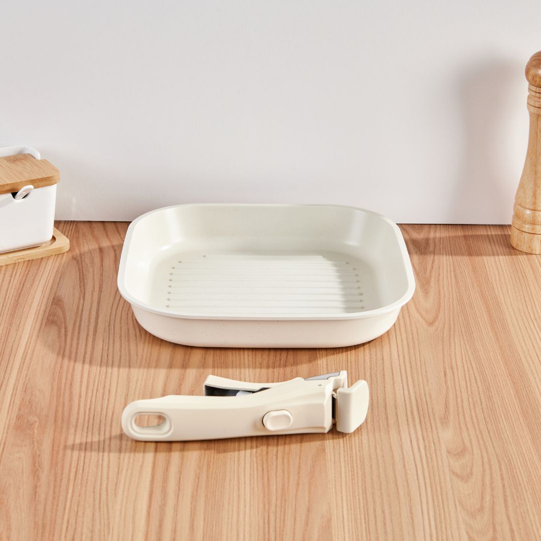 White square dish and peeler on a wooden surface with a neutral background