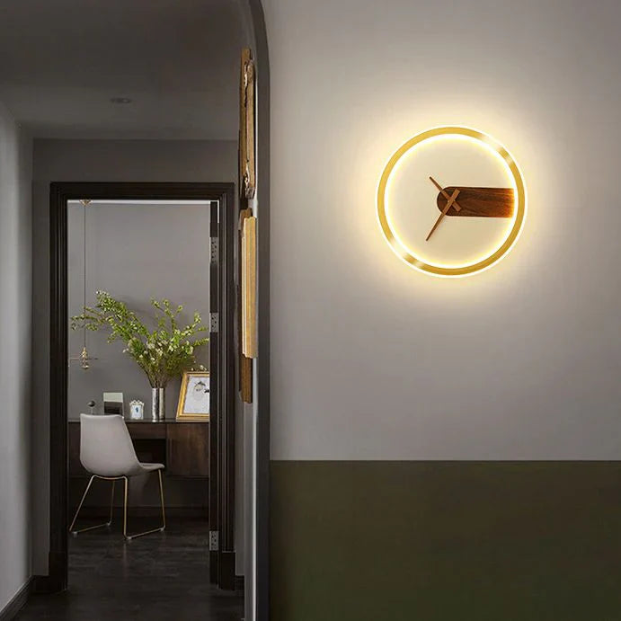 Modern wall clock with glowing circular design on a neutral wall.