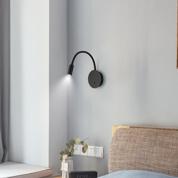 Modern wall lamp on a gray wall with a bed and curtain in the background