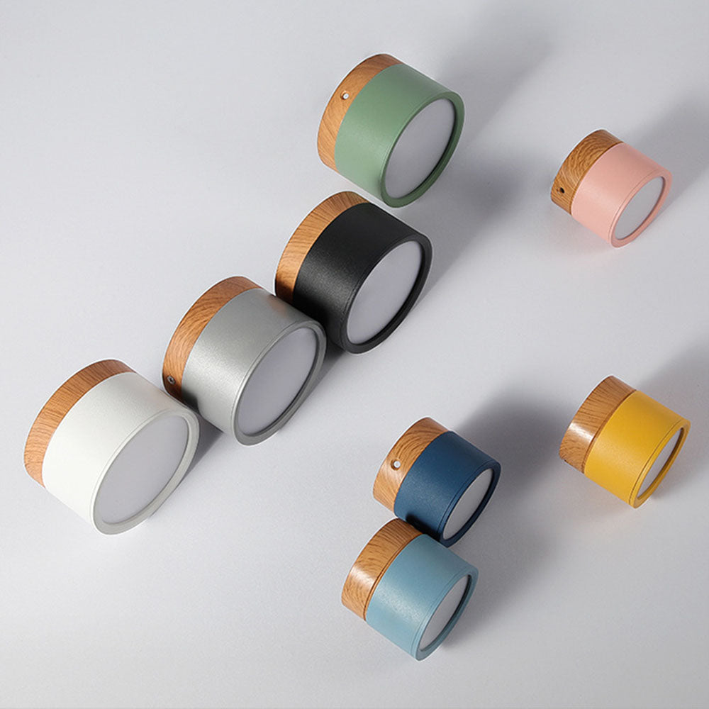 Colorful cylindrical containers with wooden tops on a light gray background