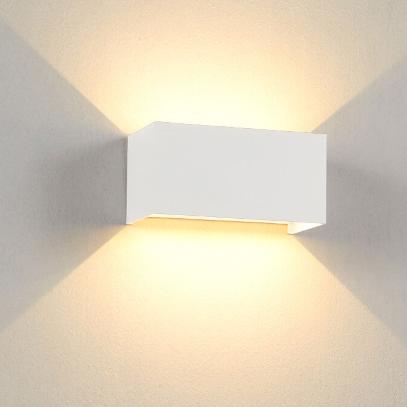 White wall-mounted LED light fixture on a gray wall