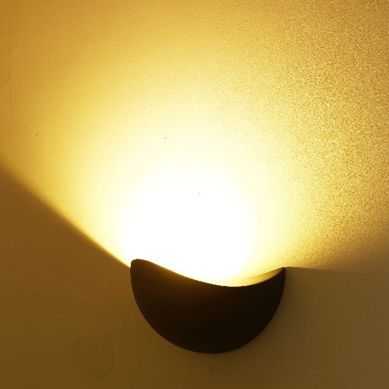 Wall-mounted light fixture casting a warm glow on a textured wall.