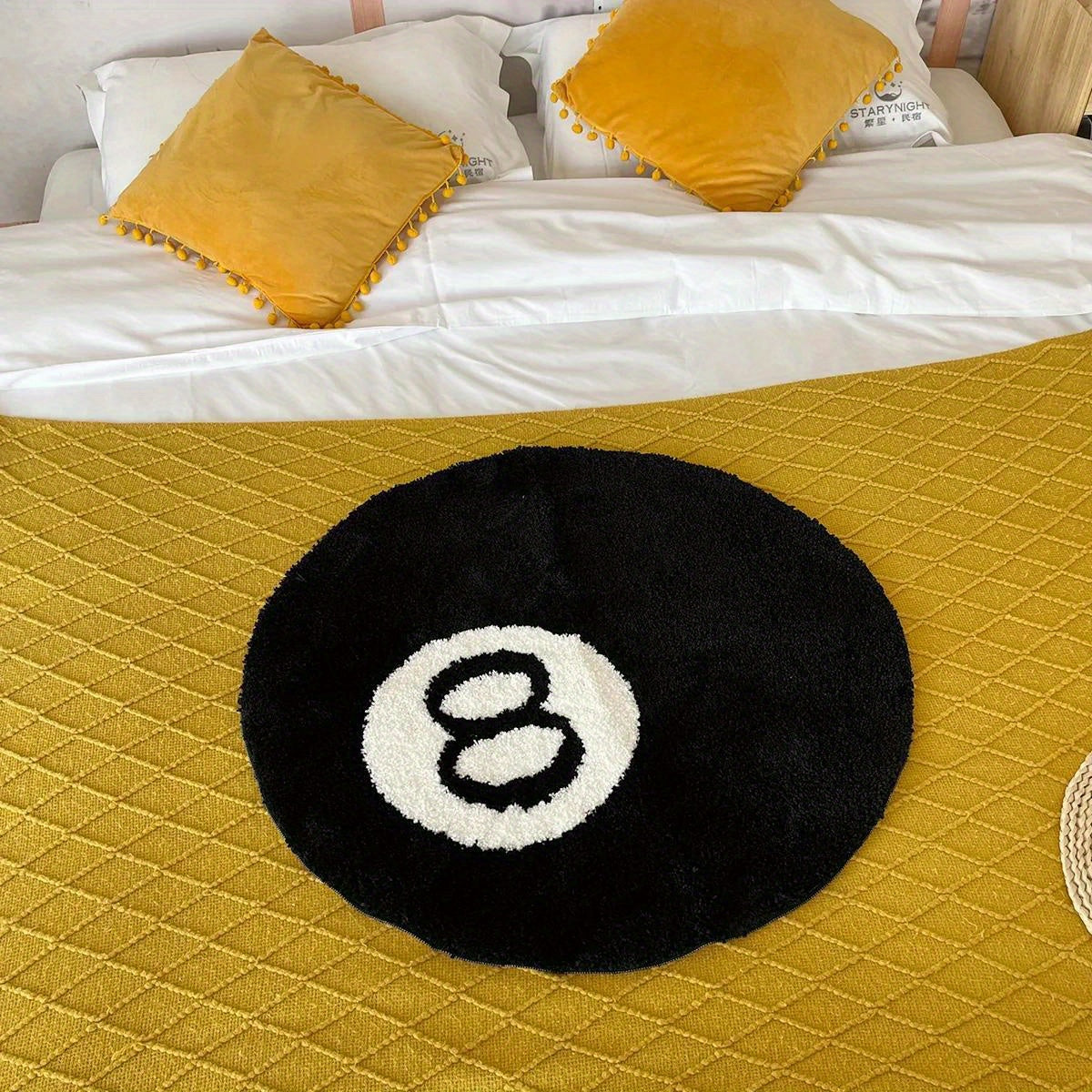 Round black rug with number 8 on a yellow quilted surface