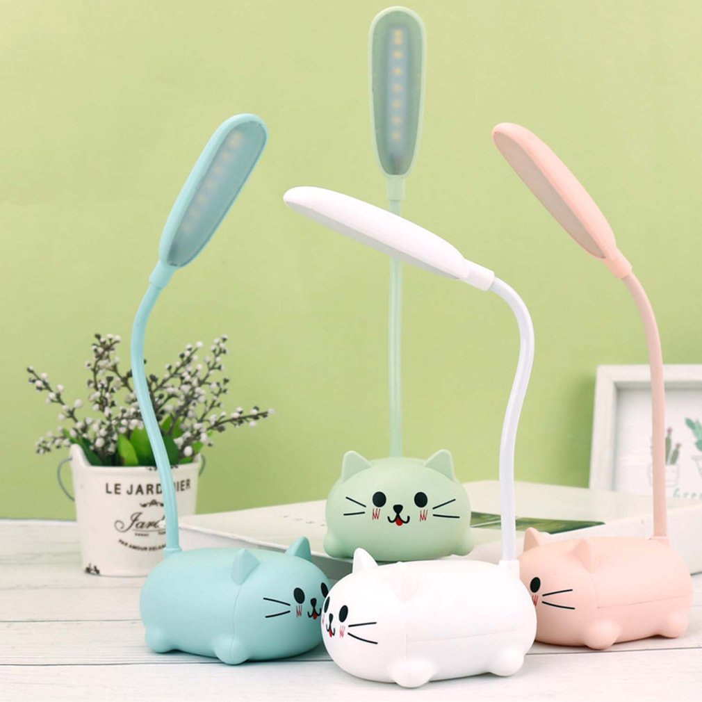 Three cartoon cat-shaped desk lamps in blue, green, and pink on a light green background.