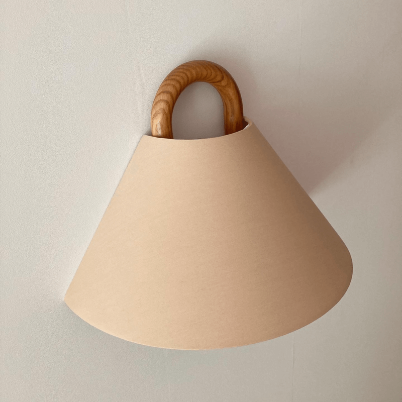 Beige lampshade with wooden handle on a plain background