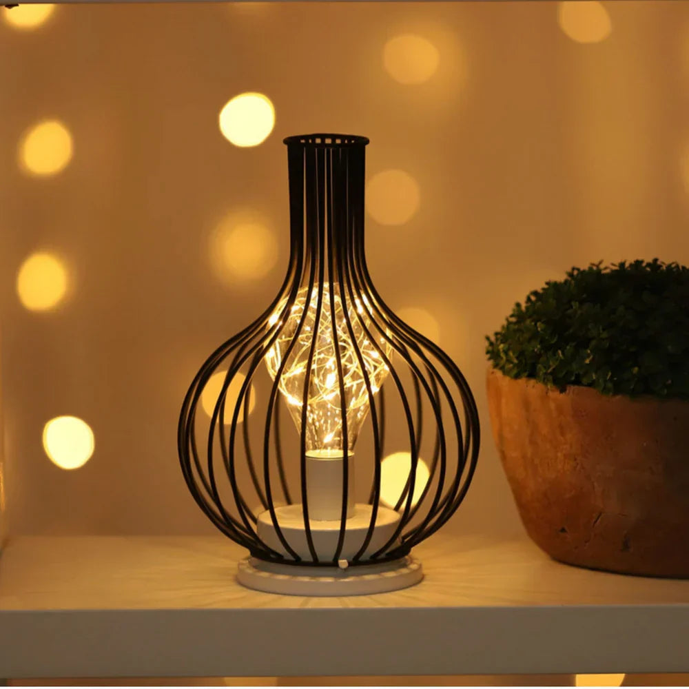 Decorative lamp with wire cage design on a shelf with a blurred bokeh background