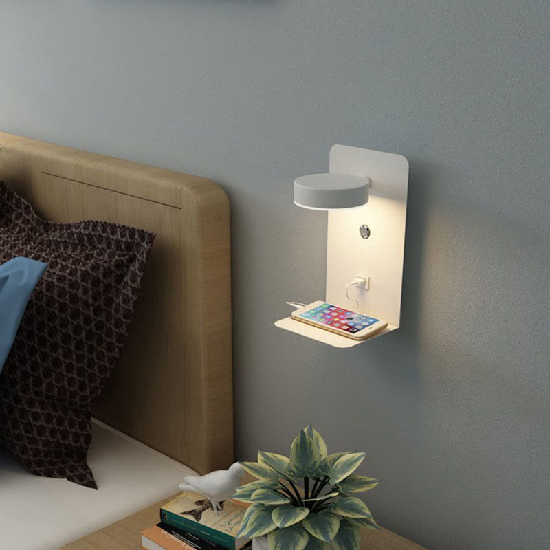 Wall-mounted night light with phone charging station in a bedroom setting