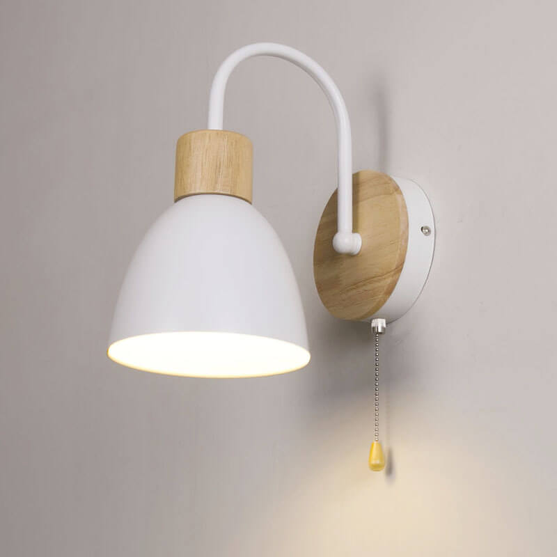 Wall-mounted lamp with white shade and wooden base on a gray wall