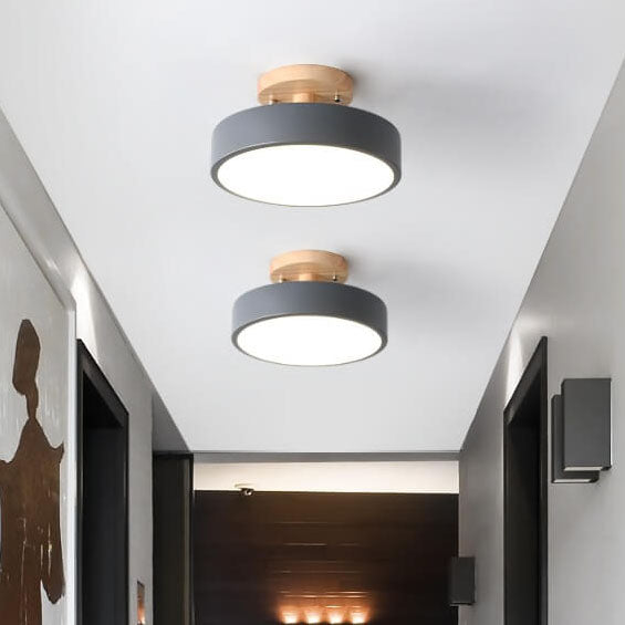 Two ceiling lights with gray and gold design in a hallway.