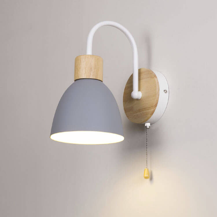 Wall-mounted lamp with gray shade and wooden base on a plain wall