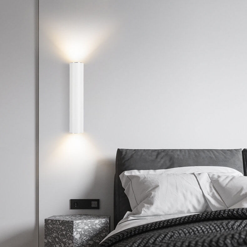 Modern bedroom with a bed and wall-mounted light fixture.