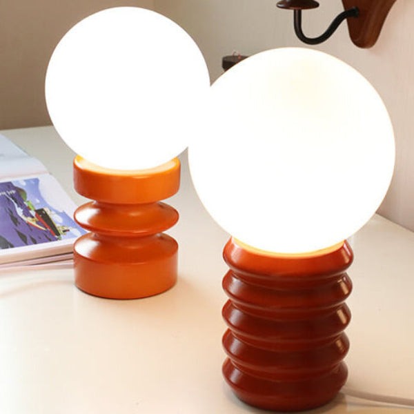 Two table lamps with orange and white design on a surface.