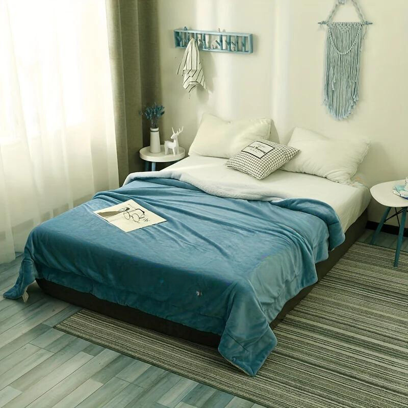 Bedroom with a bed covered in blue bedding and white pillows, surrounded by decor elements.