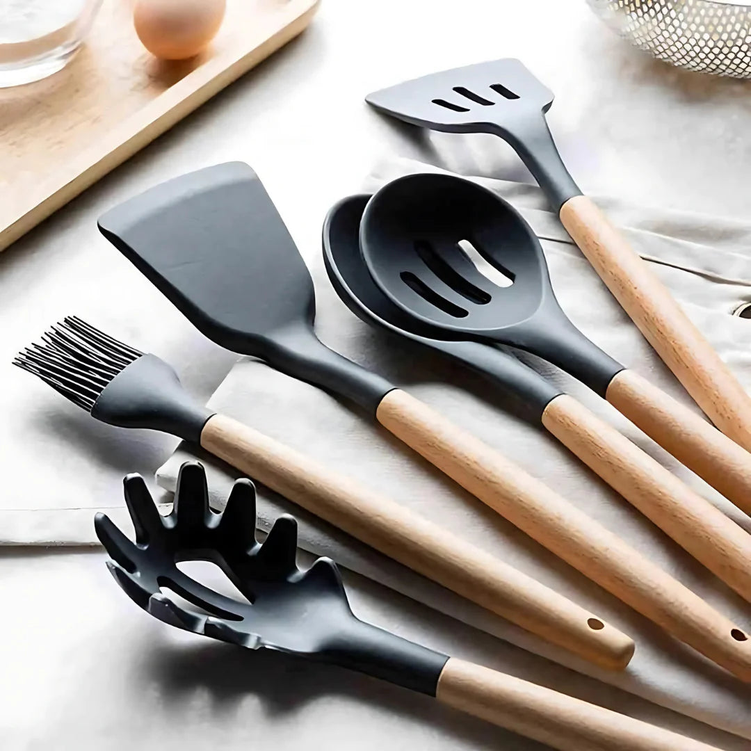 Set of kitchen utensils with wooden handles on a light surface