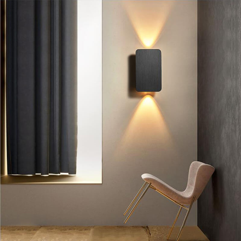 Modern wall lamp on a neutral wall with a chair in the foreground