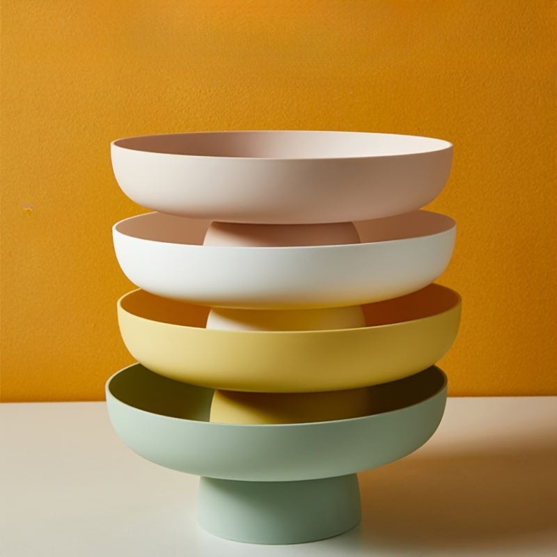 Stack of colorful bowls on a stand against an orange background
