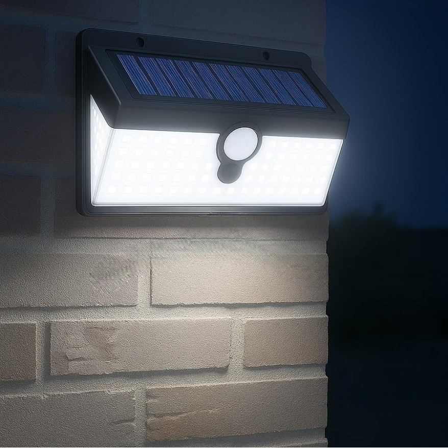 Solar-powered outdoor light fixture on a brick wall at night
