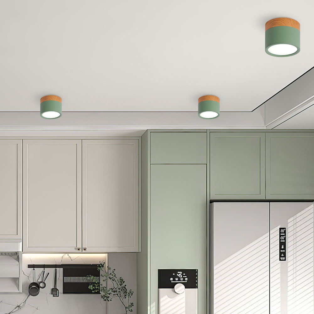 Modern kitchen interior with green ceiling lights and light gray cabinets.