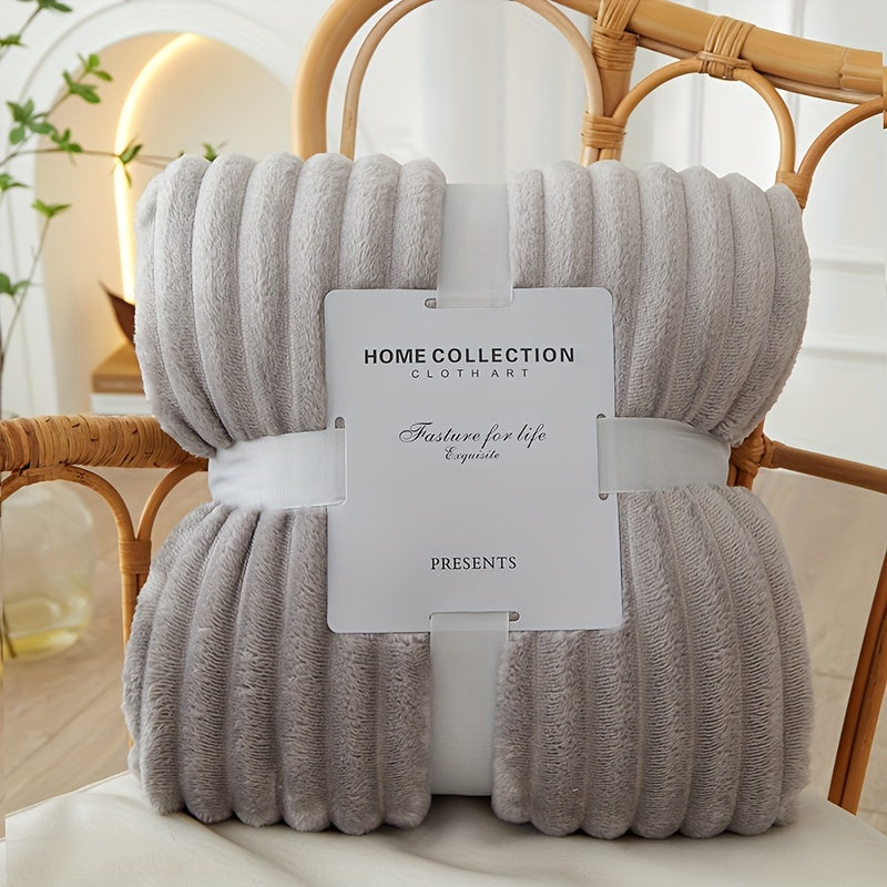 Folded gray blanket with a label on a wicker chair