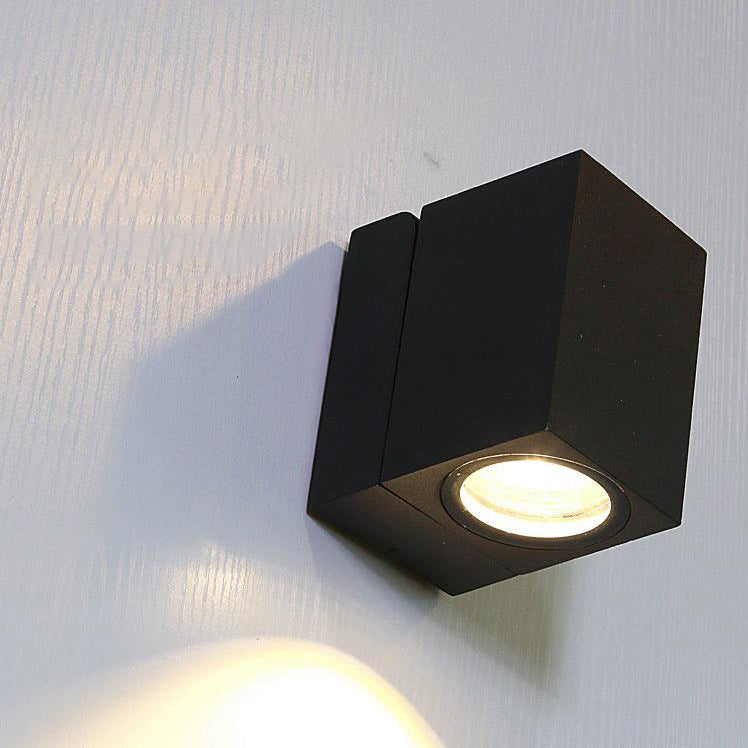 Black hexagonal wall light fixture on a white wall