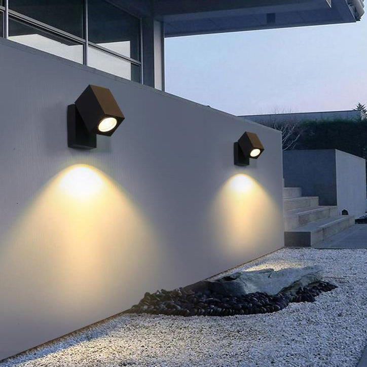 Modern outdoor wall lights on a building exterior with a clear sky.