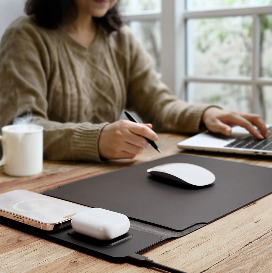 Person using a laptop with a mouse and phone on a desk