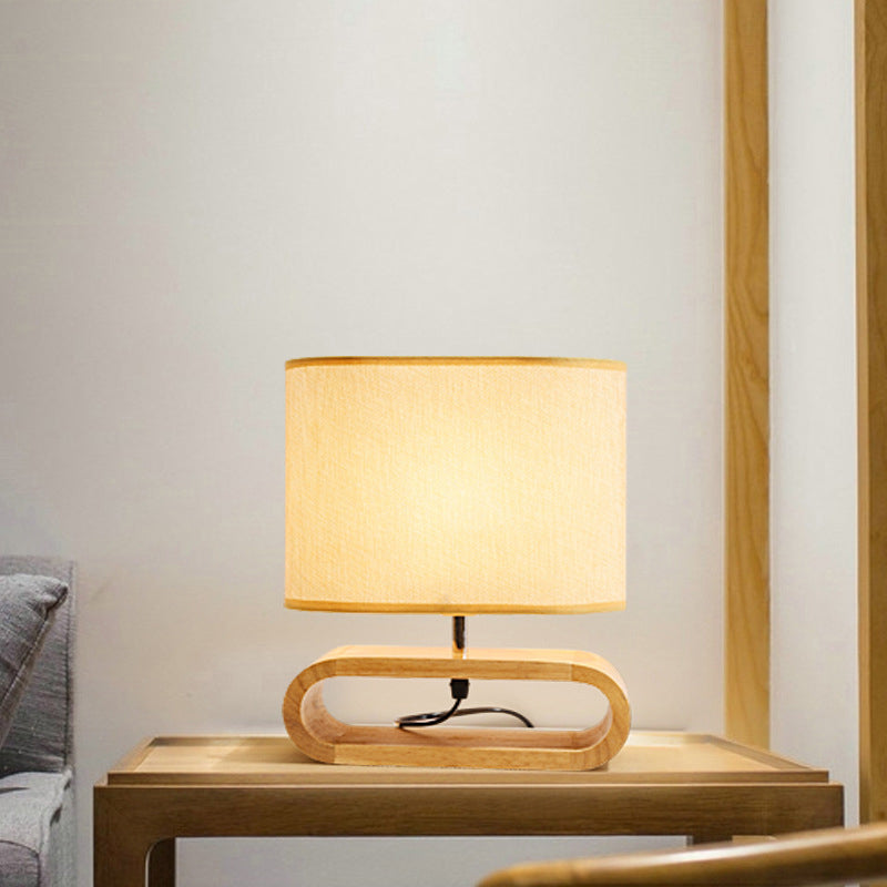 Table lamp with wooden base on a side table against a neutral wall.