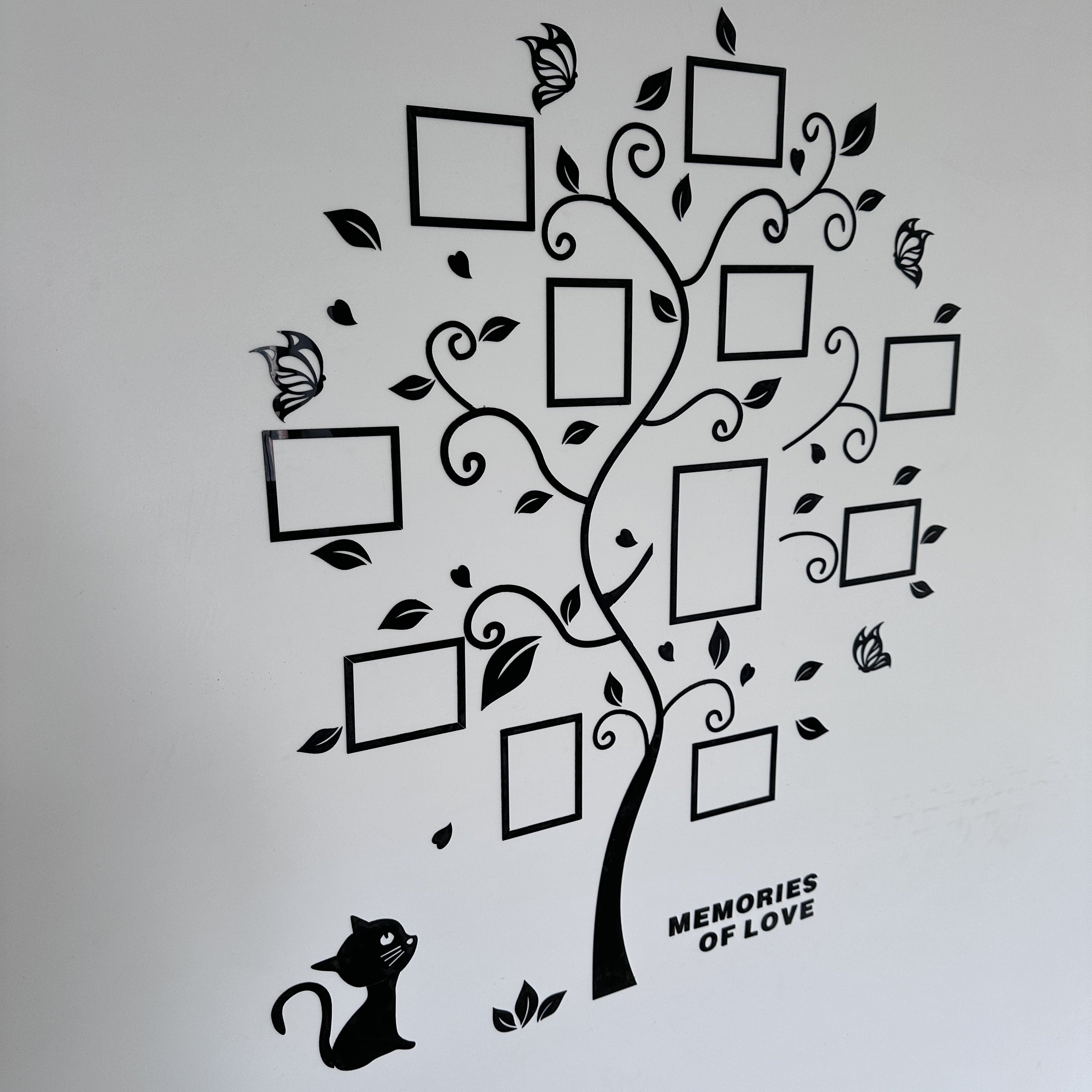Decorative wall decal of a tree with photo frames and 'Memories of Love' text on a light gray background.