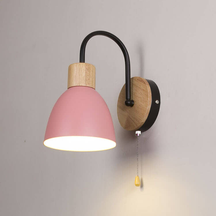 Wall lamp with pink shade and wooden base on a gray background