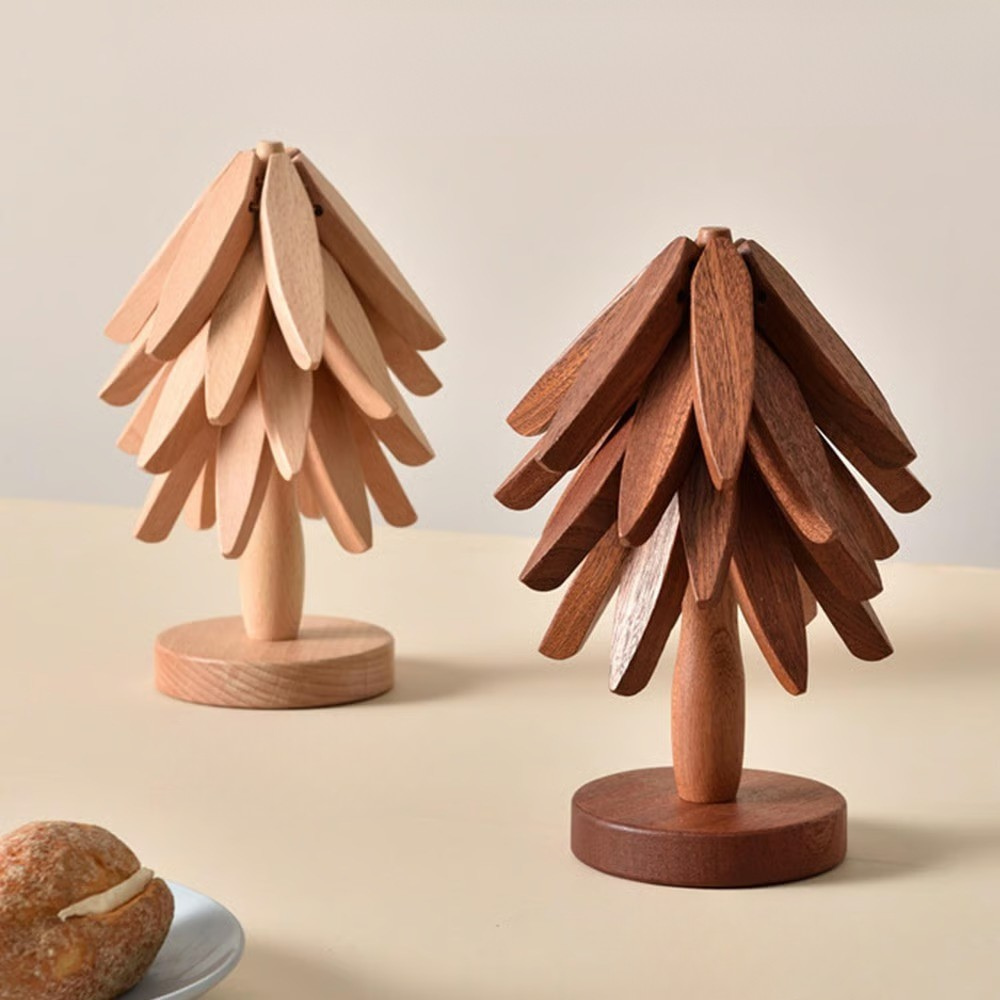 Two wooden tree sculptures on a beige surface with a light background