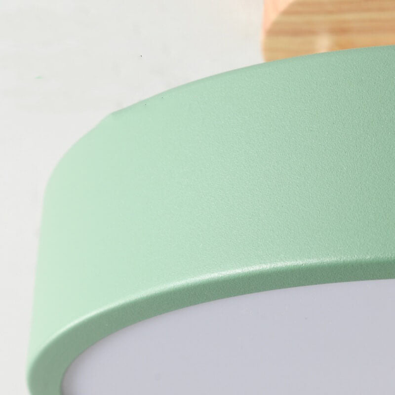 Close-up of a green lampshade with a wooden fixture on a white background