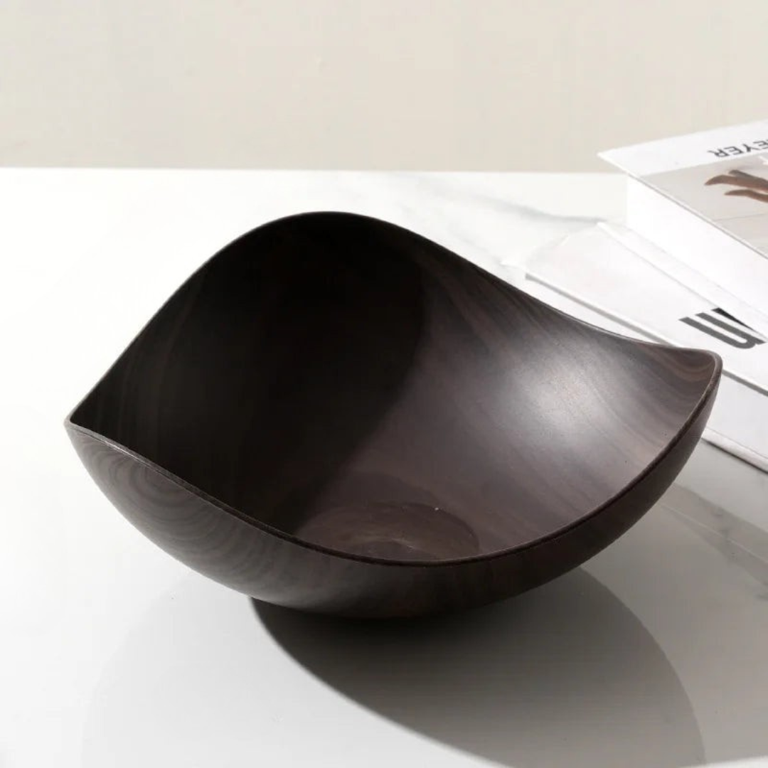 Wooden bowl on a reflective surface with a blurred background