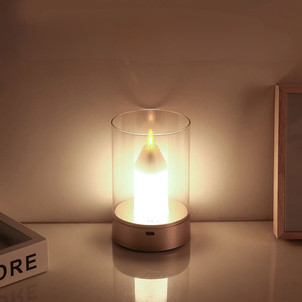 Flickering candle light in a glass container on a reflective surface with a neutral background