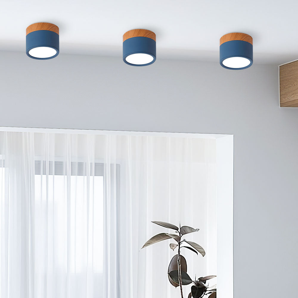 Three blue ceiling lights with wooden accents on a white ceiling.