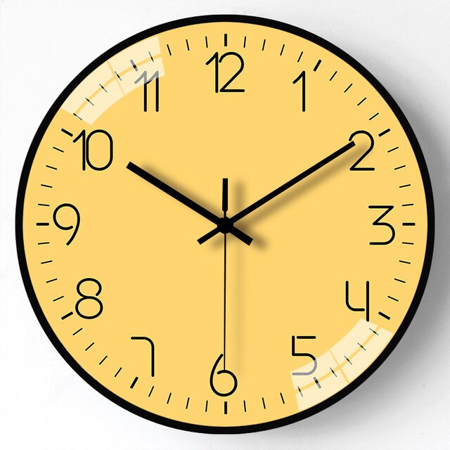 Yellow wall clock with black numbers and hands on a white background
