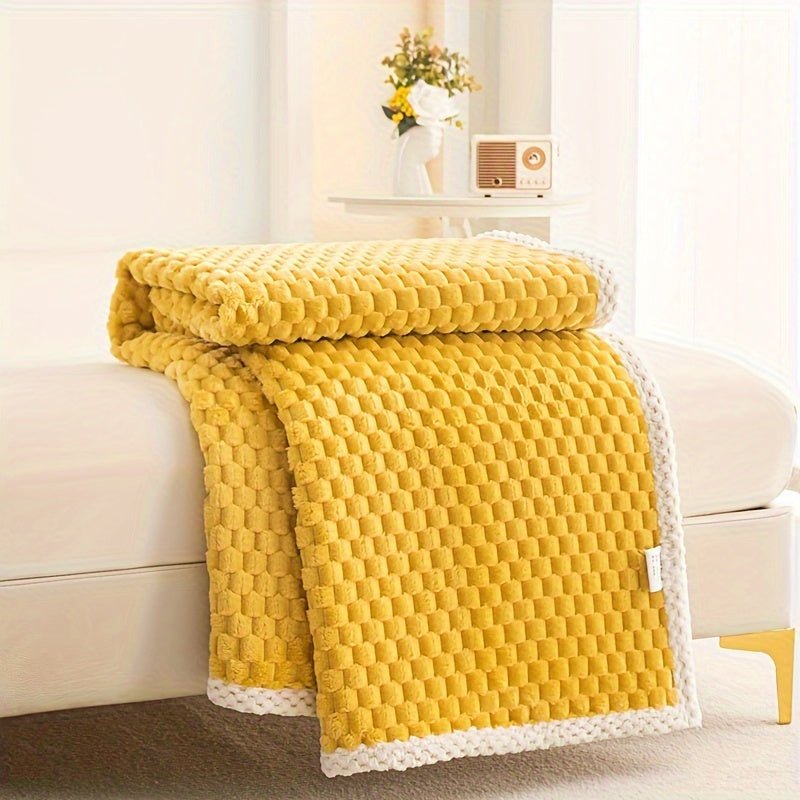 Yellow textured blanket draped over a white sofa in a living room setting.