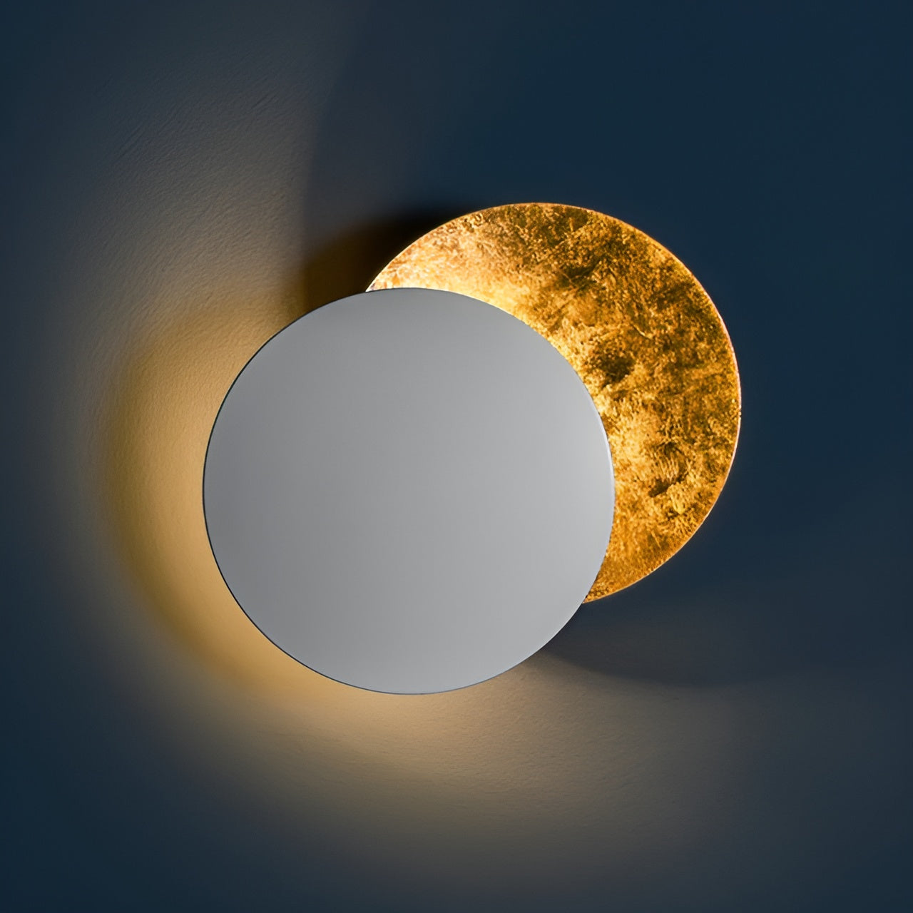 Two circular mirrors, one gold and one silver, on a dark background.