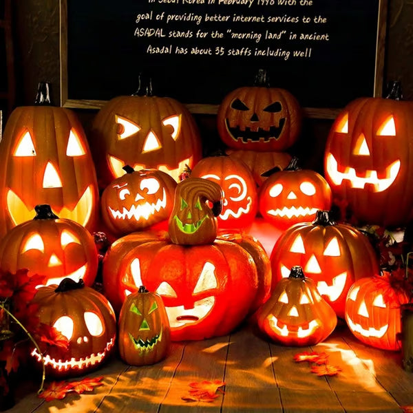 Collection of carved Halloween pumpkins with glowing lights on a wooden surface.
